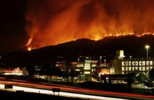 Nighttime wildfire approaching a shopping center in a commercial district
